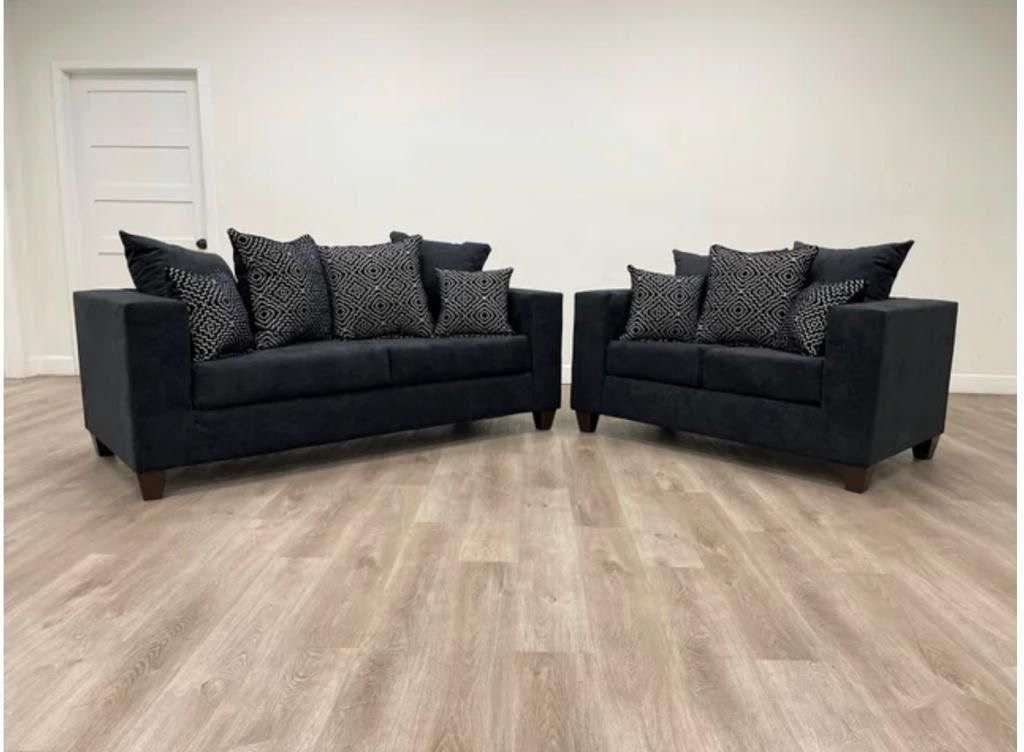 Black sofa and loveseat set with diamond pattern pillows